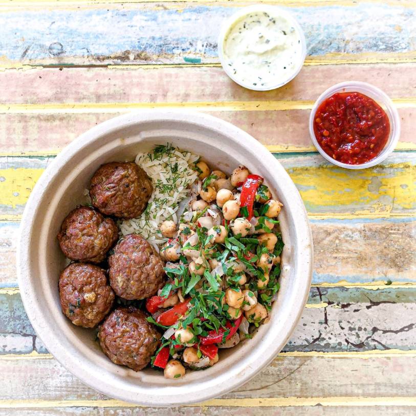 Sumac's Turkish Kofte Rice Bowl features house-made roasted ground lamb and beef shoulder balls, fragrant basmati rice, vibrant fresh dill, zesty chickpea salad, and a creamy fresh herb labneh sauce.
