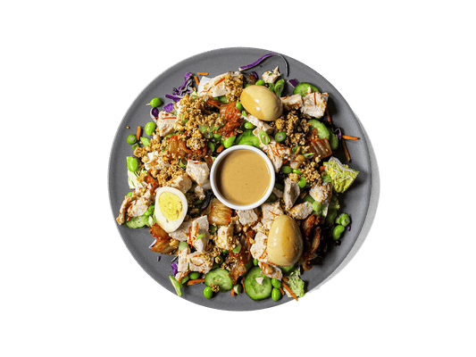 A bold, refreshing bowl packed with tangy kimchi, crisp cucumbers, and protein-rich sous vide chicken tossed with Korean chili threads. Layered with edamame, vibrant veggies, and a marinated soy egg, then finished with a creamy cashew dressing and a crunchy peanut-sesame topping. High in protein, full of probiotics, and rich in healthy fats—crafted for flavor and longevity.