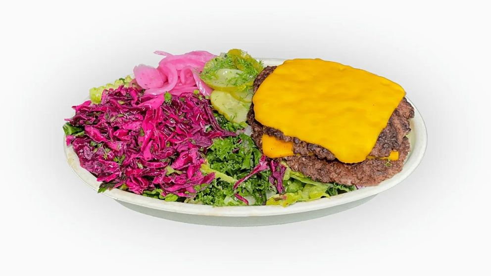 NomNom Burger's Protein Style Smash Burger offers a juicy beef patty wrapped in crisp lettuce instead of a bun, topped with tangy pickled onions and melted American cheese. This low-carb, high-flavor option delivers all the deliciousness of a classic burger with a fresh, lighter twist.