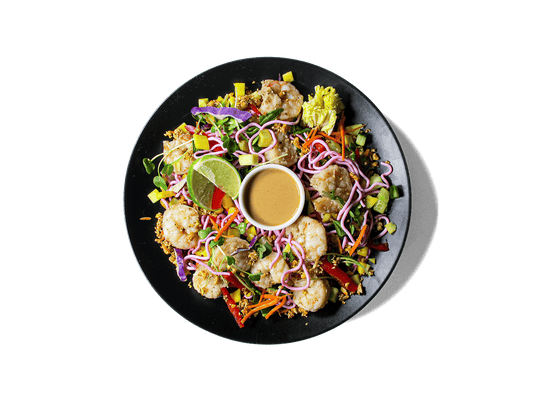 A vibrant, protein-packed bowl featuring shrimp, beet-dyed egg white noodles, and a rainbow of crisp veggies like mango, cabbage, bell pepper, and sprouts. Finished with fresh herbs, tangy lime, and a creamy, house-made cashew dressing. Light, refreshing, and rich in antioxidants—perfect for longevity and clean energy.